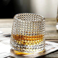 Rotating Whisky Glass with Textured Tilted Base for Swirling Spirits