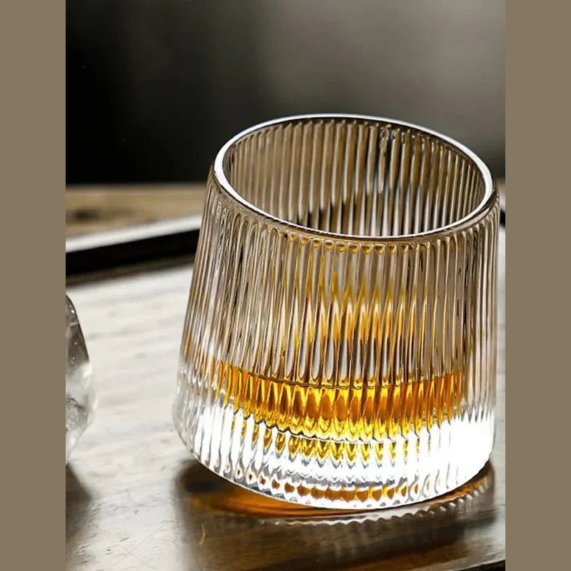 Rotating Whisky Glass with Textured Tilted Base for Swirling Spirits